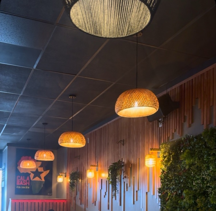 The Calabash dining room: woven lamps, wood slats and a green wall